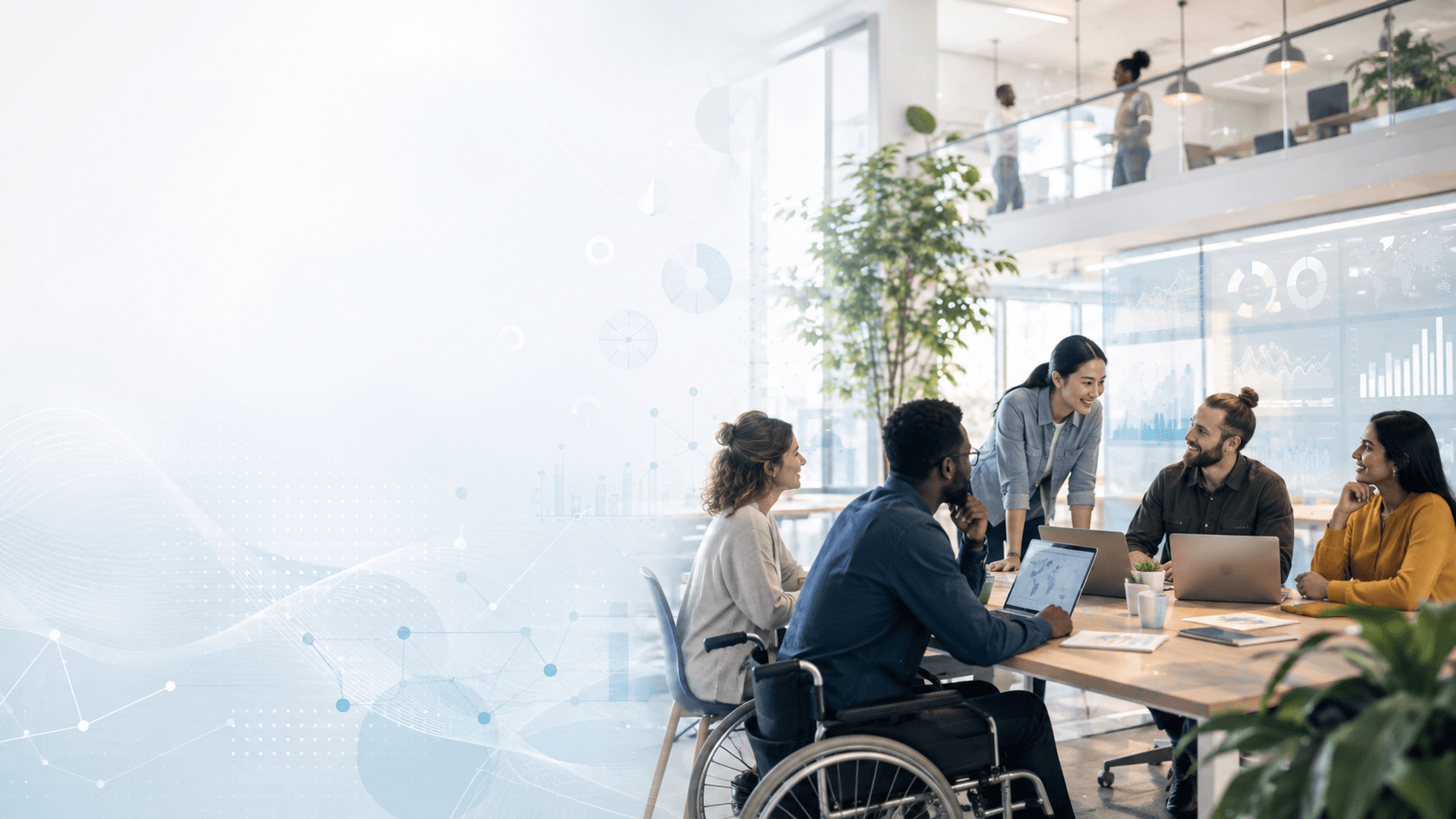 A diverse FundWisr team, including a colleague using a wheelchair, collaborating around a laptop in a bright office